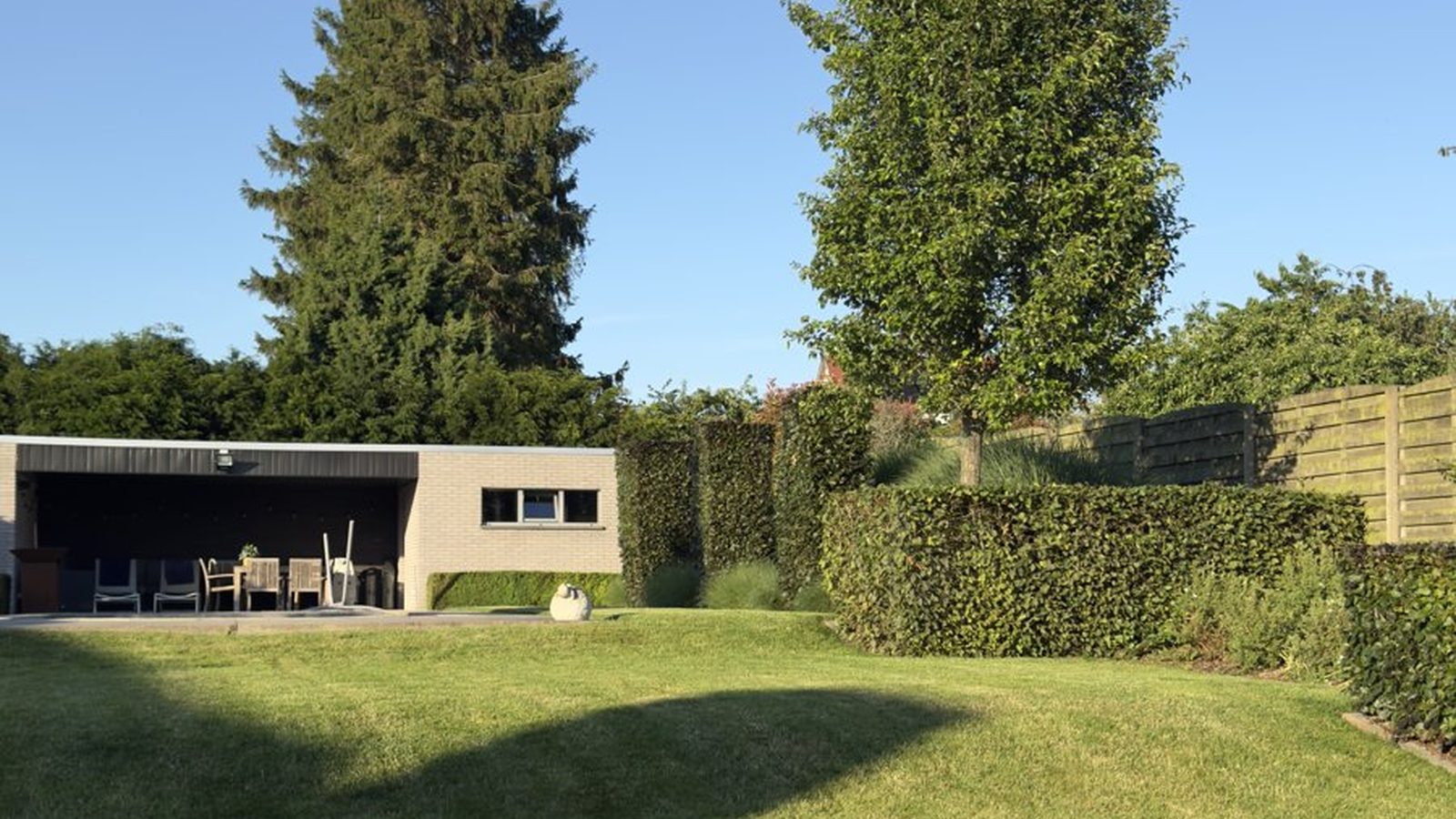 Ruim onderhouden gazon met volgroeide bomen