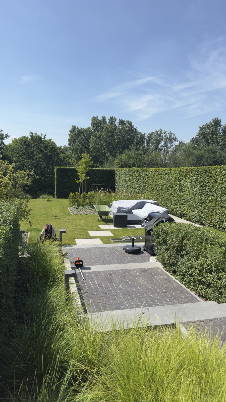 Verzorgde tuin met gemaaid gazon en strakke haag